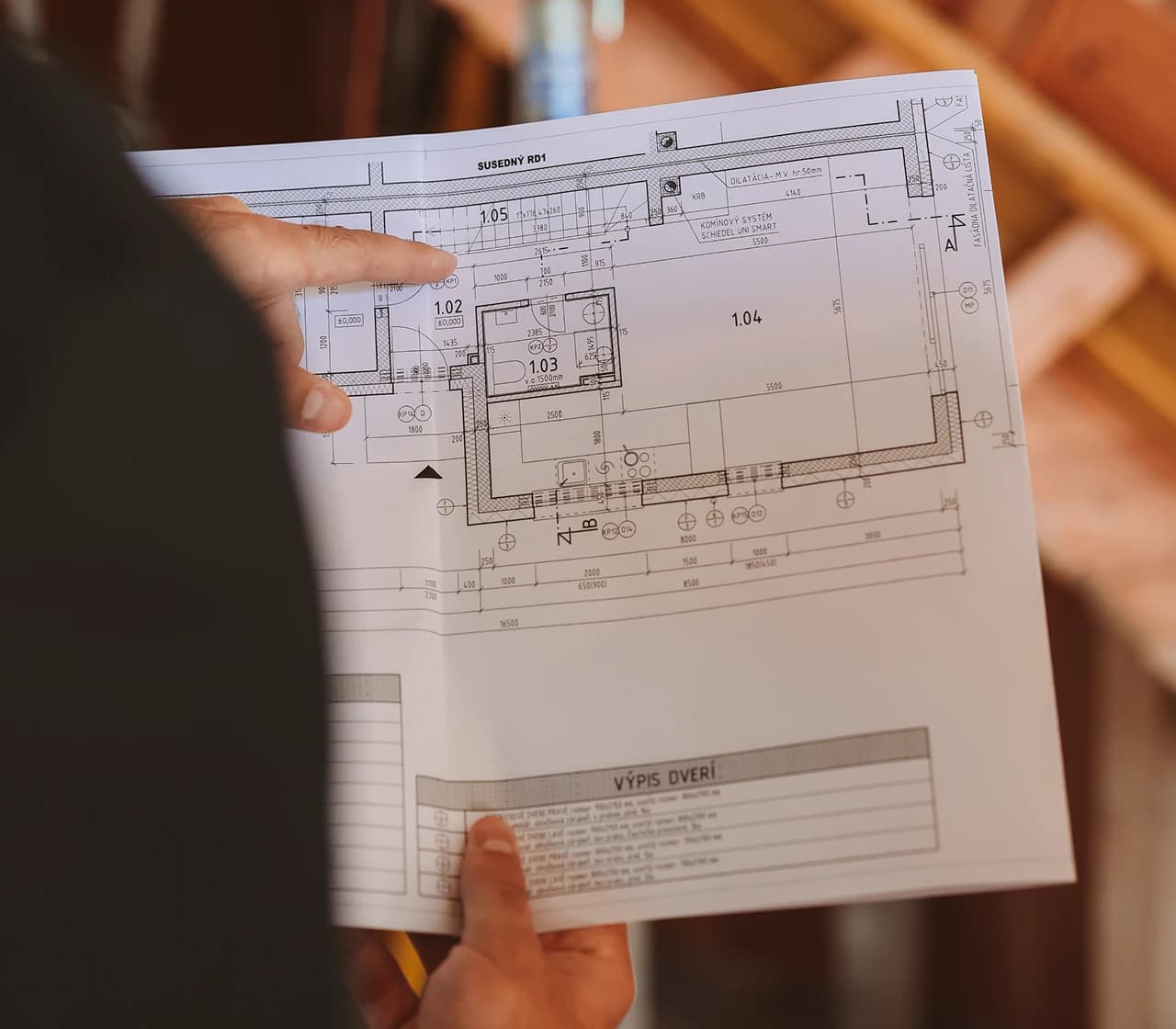 Projektant ukazuje na výkres projektu novej nehnuteľnosti